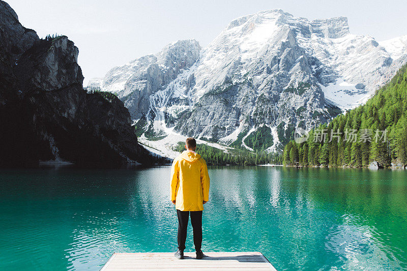 身穿雨衣的男人在Dolomites阿尔卑斯山的Lago Di braes享受夏天的早晨